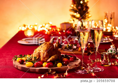 クリスマスパーティー　赤いテーブルクロスの上にはローストチキンにシャンパン 105659708