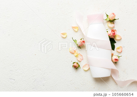 Fancy healthcare bottles for cream with rose flower. Natural oranic spa cosmetics concept. Mockup, template, Top view Fancy healthcare bottles for cream with rose flower. Natural oranic spa cosmetics concept. Mockup, template, Top view 105660654