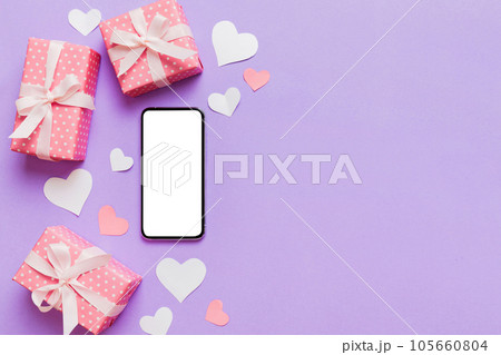 mobile phone with blank screen on colored background with hearts, valentine day concept top view flat lay mobile phone with blank screen on colored background with hearts, valentine day concept top view flat lay 105660804