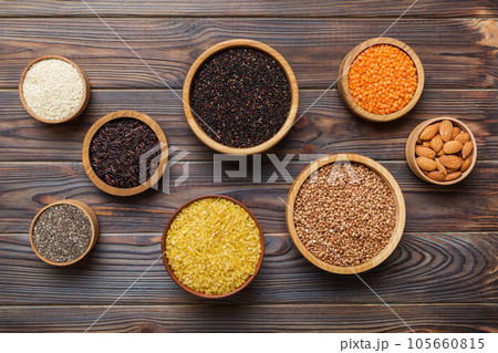 Various superfoods in smal bowl on colored background. Superfood as rice, chia, quinoa, lentils, nuts, sesame seeds, almonds. top view copy space 105660815