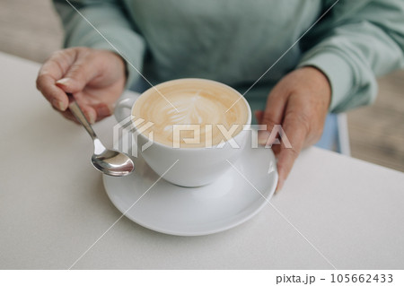 Closeup image of woman with Cappuccino coffee mugs in cafe 105662433