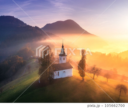 Aerial view of small church on the hill and low clouds at sunrise 105662700