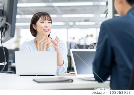 オフィスでパソコンを操作しながら会議をする男女の若いエンジニア オフィスでパソコンを操作しながら会議をする男女の若いエンジニア 105662918