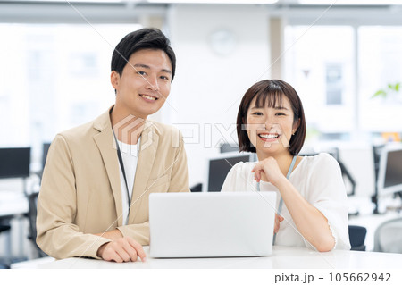 オフィスでパソコンを操作しながら会議をする男女の若いエンジニア 105662942