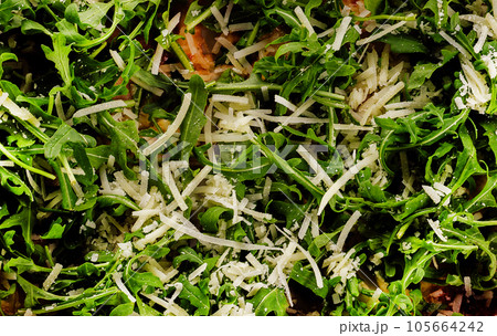 Pizza with arugula and parmesan on black Pizza with arugula and parmesan on black 105664242