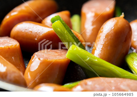 ウインナーソーセージとにんにくの芽をフライパンで炒める調理シーン。 ウインナーソーセージとにんにくの芽をフライパンで炒める調理シーン。 105664985