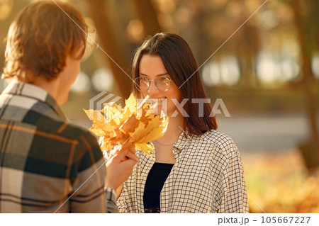 Couple in a park. Guy in a white t-shirt. Golden autumn. 105667227