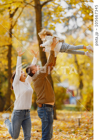 Family with cute little daughter. Father in a brown sweater. Family in a autumn field Family with cute little daughter. Father in a brown sweater. Family in a autumn field 105667345