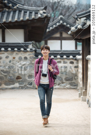 A young man holding a camera and taking pictures during a trip to Korea A young man holding a camera and taking pictures during a trip to Korea 105669112