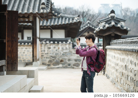 A young man holding a camera and taking pictures during a trip to Korea 105669120