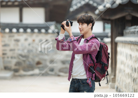 A young man holding a camera and taking pictures during a trip to Korea 105669122