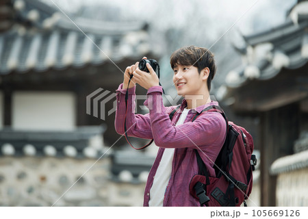 A young man holding a camera and taking pictures during a trip to Korea 105669126