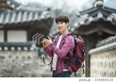 A young man holding a camera and taking pictures during a trip to Korea A young man holding a camera and taking pictures during a trip to Korea 105669128