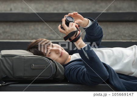 A young man holding a camera and taking pictures during a trip to Korea 105669147