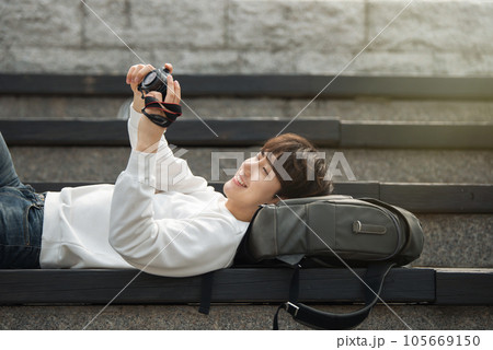 A young man holding a camera and taking pictures during a trip to Korea 105669150