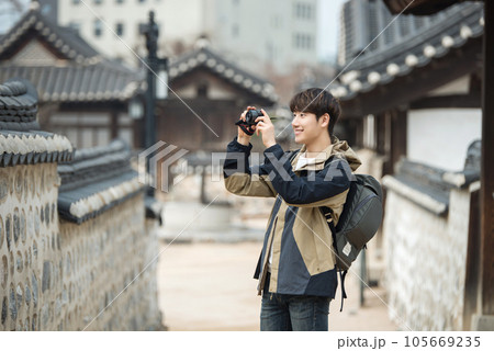 A young man holding a camera and taking pictures during a trip to Korea 105669235