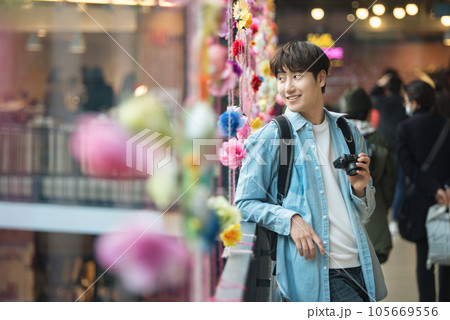 A young man holding a camera and taking pictures during a trip to Korea A young man holding a camera and taking pictures during a trip to Korea 105669556