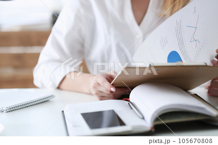 Female hands hold clipboard pad with financial Female hands hold clipboard pad with financial 105670808