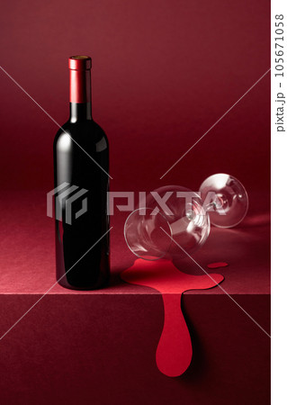 Bottle and glass of red wine on a red background. Bottle and glass of red wine on a red background. 105671058