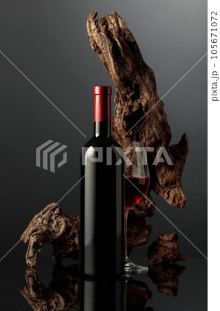 Red wine and old snag on a black background. Red wine and old snag on a black background. 105671072