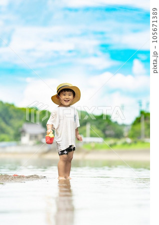 夏の海辺に立つ子供の写真素材 [105671389] - PIXTA