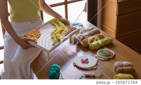 Needlework concept, Women smiling and looking on embroidery fabric punch frame diy performance 105671784
