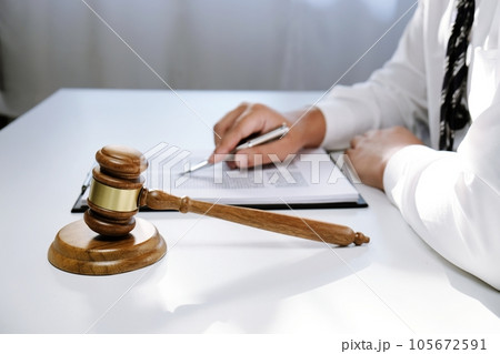 Legal counsel presents to the client a signed contract with gavel and legal law. justice and lawyer concept. 105672591
