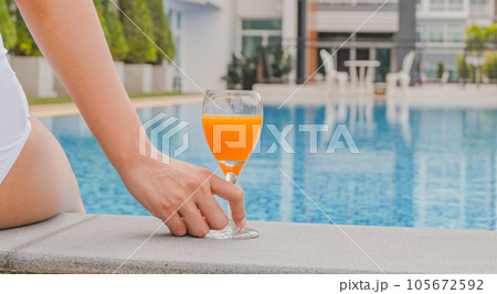 Summer holiday Young asian Beautiful woman relaxing in swimming pool at spa resort. Beautiful tropical beach front hotel resort with swimming pool 105672592