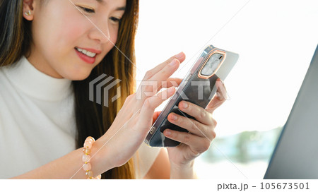 A woman is using a smart phone for various daily activities. The photo is of high quality. 105673501