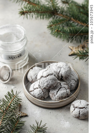 Chocolate chip cracked cookies on a plate on light gray table background with fir tree branches. Christmas food Chocolate chip cracked cookies on a plate on light gray table background with fir tree branches. Christmas food 105673945