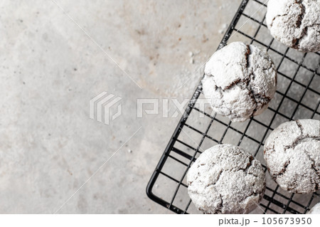 Chocolate chip cookies with cracks on metallic rack on light gray background with copy space Chocolate chip cookies with cracks on metallic rack on light gray background with copy space 105673950