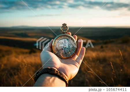 Beautiful landscape with old compass on traveler's hand. The concept of navigating the search for your own path. AI generated 105674411