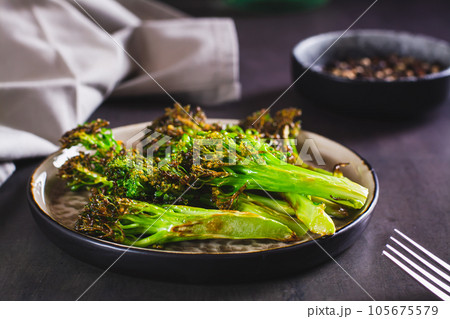 Fried green broccoli sprouts on a plate on the table 105675579