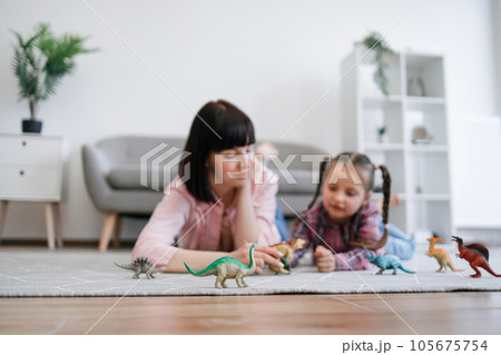Animal figurines being placed by female players on carpet 105675754