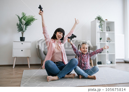 Happy family gamers with joysticks raising hands in success 105675814