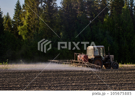 Mist cloud created by tractor mounted crop sprayer spreading herbicides in an agricultural field. Mist cloud created by tractor mounted crop sprayer spreading herbicides in an agricultural field. 105675885