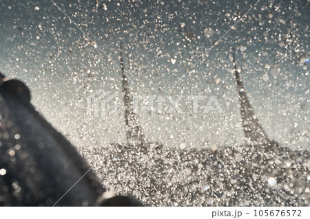 The view through the spray of how the two sailboats are heeling at sunset, boat roll, splashes shine in the sun, sailors on the boards 105676572