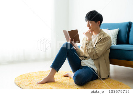 リビングで読書をする若い男性 リビングで読書をする若い男性 105679713