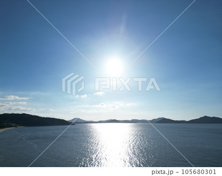 【ドローン】夏の照りつける太陽の光を反射する海を眺める 105680301