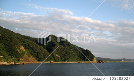 夕日に照らされる弥彦岬と日本海と染まり始めた雲 105682027