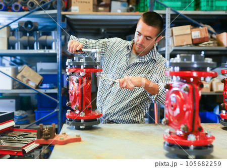 Worker fixing pipe fitting in repair service 105682259