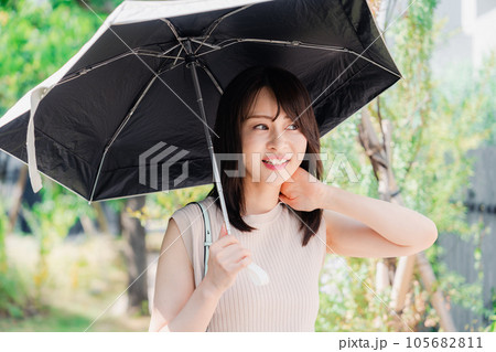 日傘を差して外を歩く若い女性 日傘を差して外を歩く若い女性 105682811