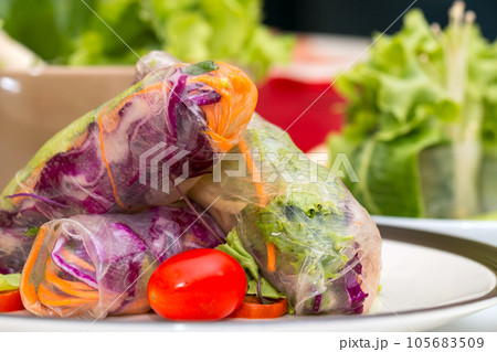 Close up of Fresh spring roll on disk placing together with other fresh vegetable 105683509