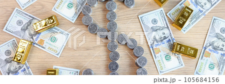 Coins in shape of dollar symbol and a lot of gold bars with US dollar bills on table, top view. 105684156