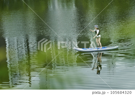 休日の川でサップを楽しむ日本人の女性 105684320