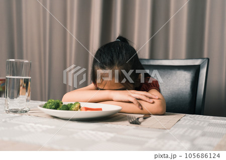 Little cute kid girl refusing to eat healthy vegetables. Children do not like to eat vegetables. Little cute kid girl refusing to eat healthy vegetables. Children do not like to eat vegetables. 105686124