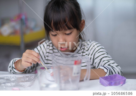 Cute little girl making DIY plaster and painting at home. Children paint on plaster sculptures with family on holiday. Imagination and creativity activities. 105686586
