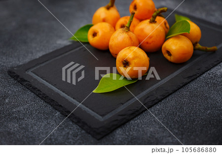 Loquat Medlar fruit isolated on dark table background Loquat Medlar fruit isolated on dark table background 105686880