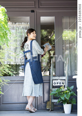 カフェの開店準備をする若い女性 105686908