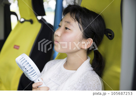 熱中症ぎみになって車で涼む小学生女の子 105687253